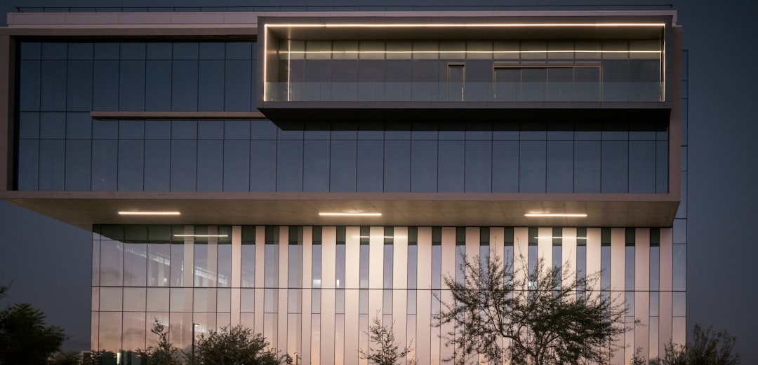 Modern commercial office building with illuminated glass exterior at dusk